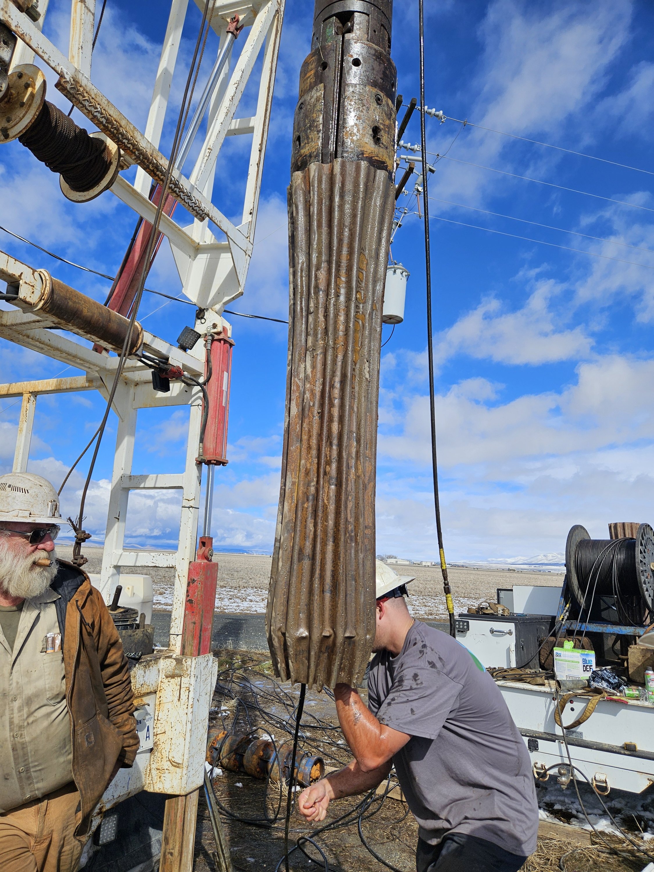 Workers setting up a well drill